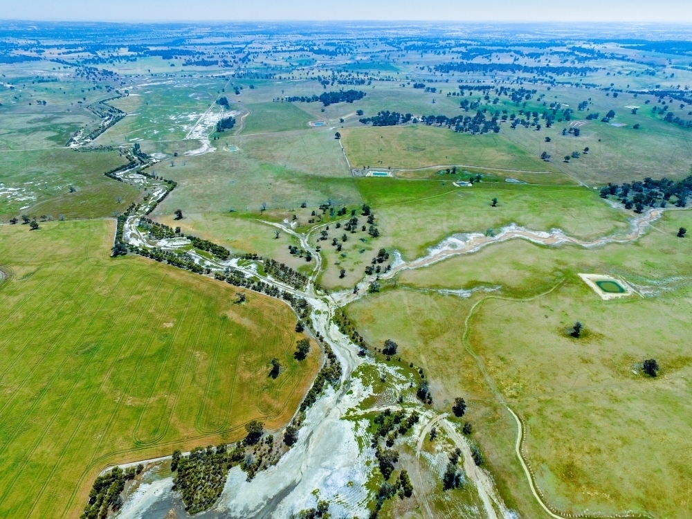 Aerial landscape of farm land with salt-affected creek line - Australian Stock Image