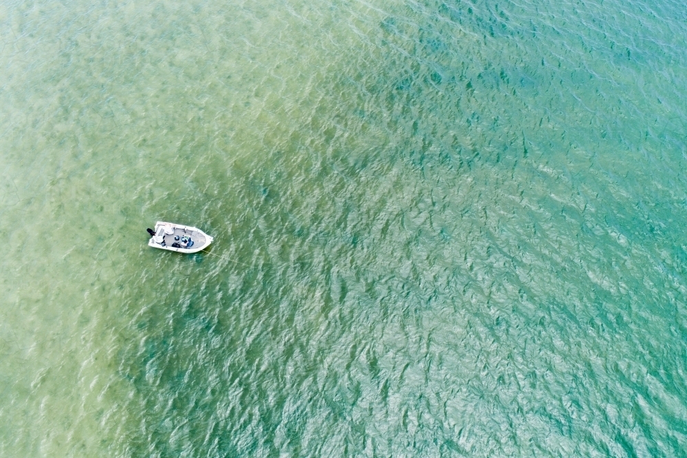 Aerial looking down on fishing boat in shallow estuary water. - Australian Stock Image