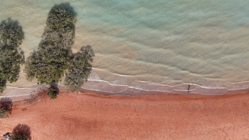 Aerial of aqua water meeting red sand - Australian Stock Image