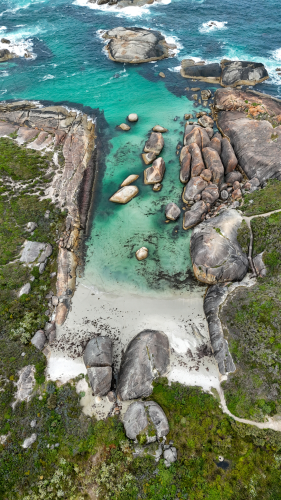 Aerial of beach with aqua water and large rocks - Australian Stock Image