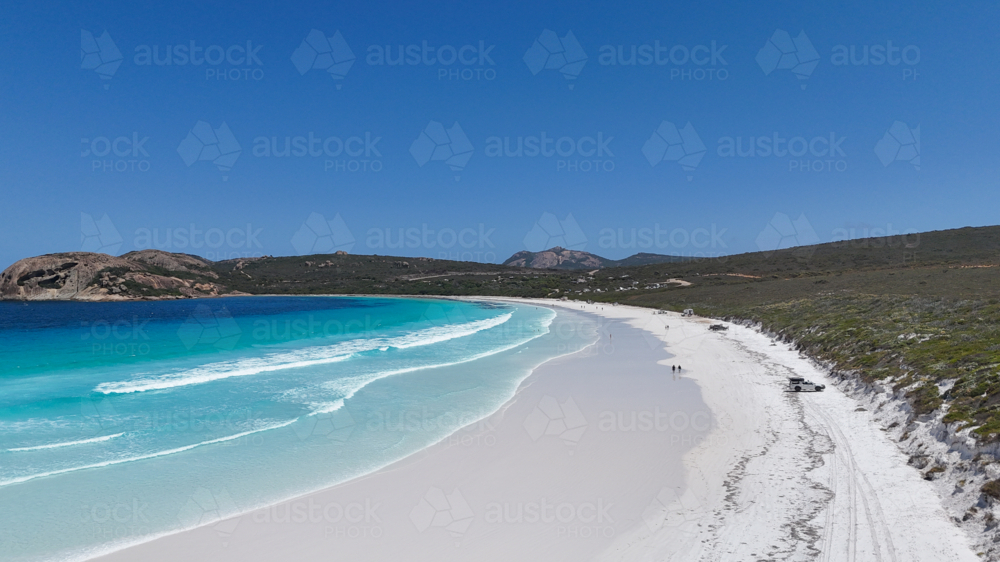 Aerial of beach with white sand and crystal blue water on a sunny day - Australian Stock Image
