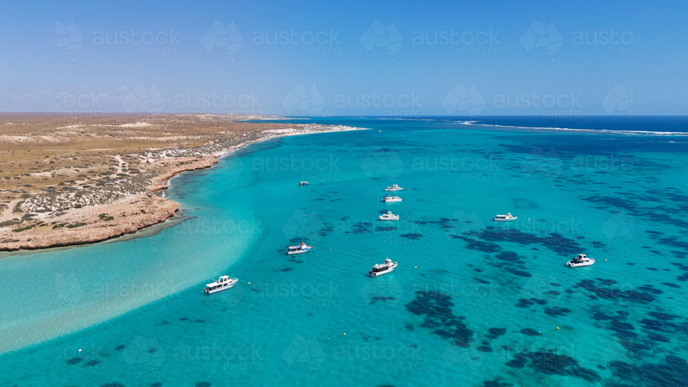 Aerial of boats above the reef close to land - Australian Stock Image