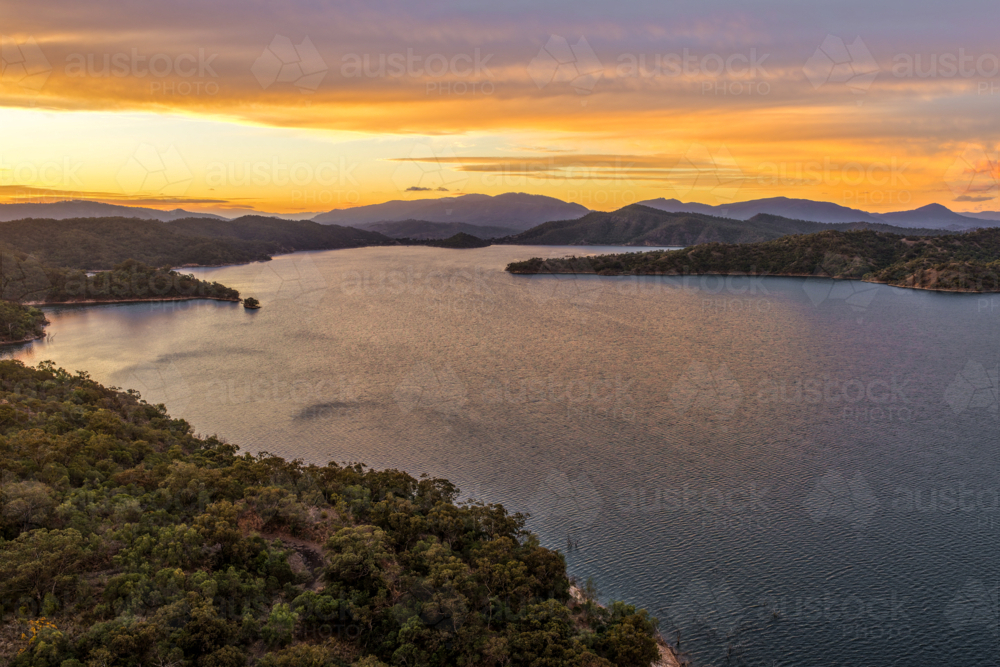 Aerial of Glenbawn Dam at sunset in NSW Australia. Drone view of calm dam waters - Australian Stock Image