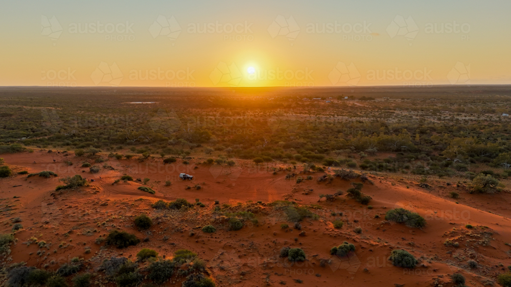 Aerial of golden hour in a remote red sand landscape - Australian Stock Image