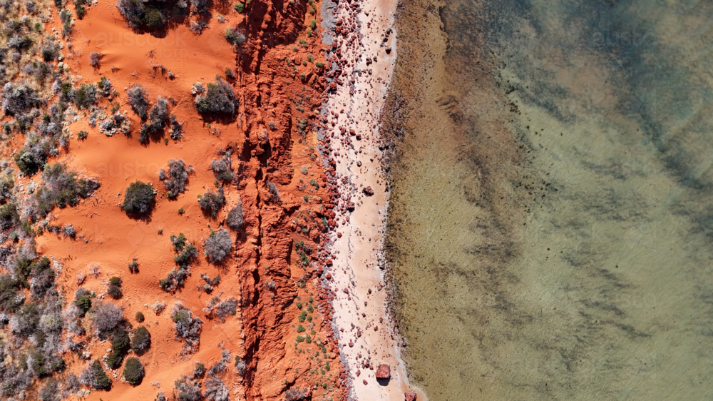 Aerial of red cliff at a remote beach - Australian Stock Image