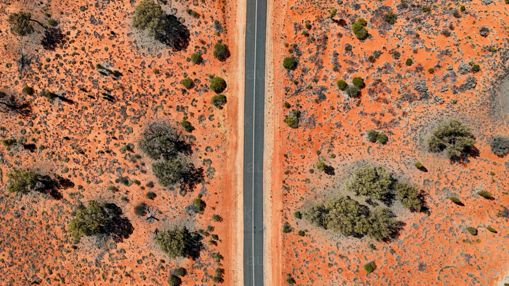 Aerial of straight road through the red outback - Australian Stock Image