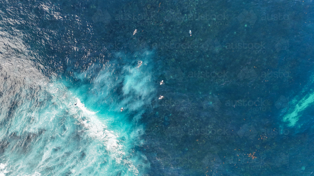 Aerial of surfers out in the water above the reef - Australian Stock Image