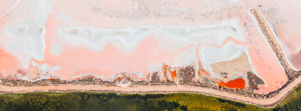 Aerial panorama of coloured evaporation ponds at a coastal salt farm - Australian Stock Image