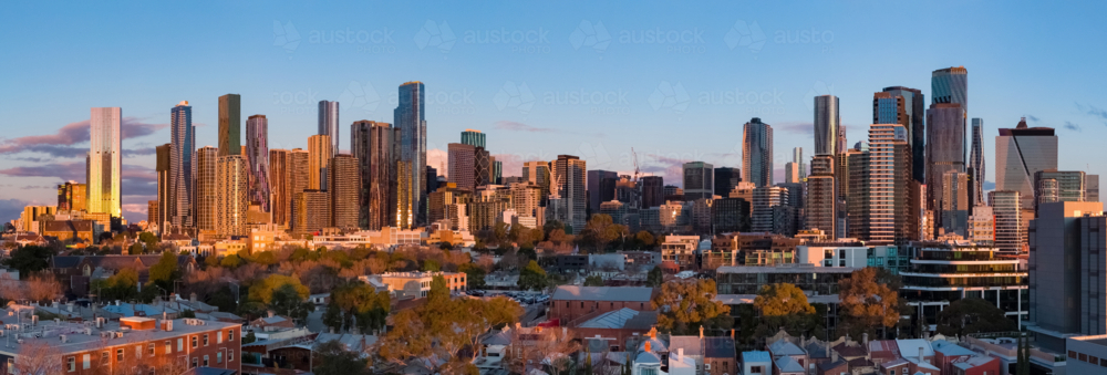 Aerial panorama of high rise buildings in a city skyline in golden evening lighting - Australian Stock Image