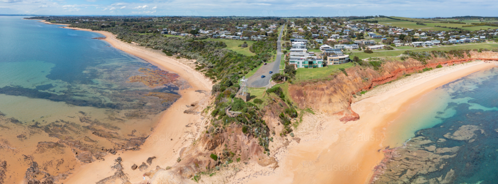 Aerial panorama of sandy beaches on both sides of a tower on a coastal headland - Australian Stock Image