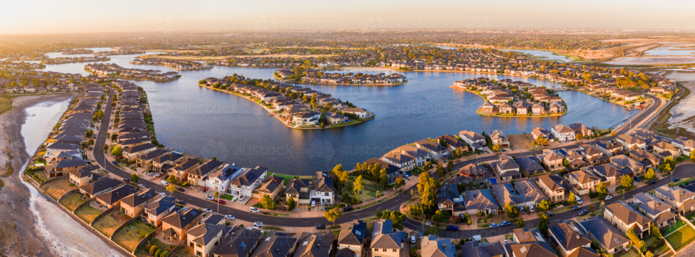 Aerial panorama view a large housing estate around manmade lakes at sunset - Australian Stock Image