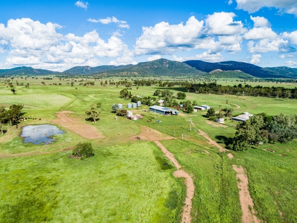 Aerial photo of dam and track to farm through green paddocks - Australian Stock Image