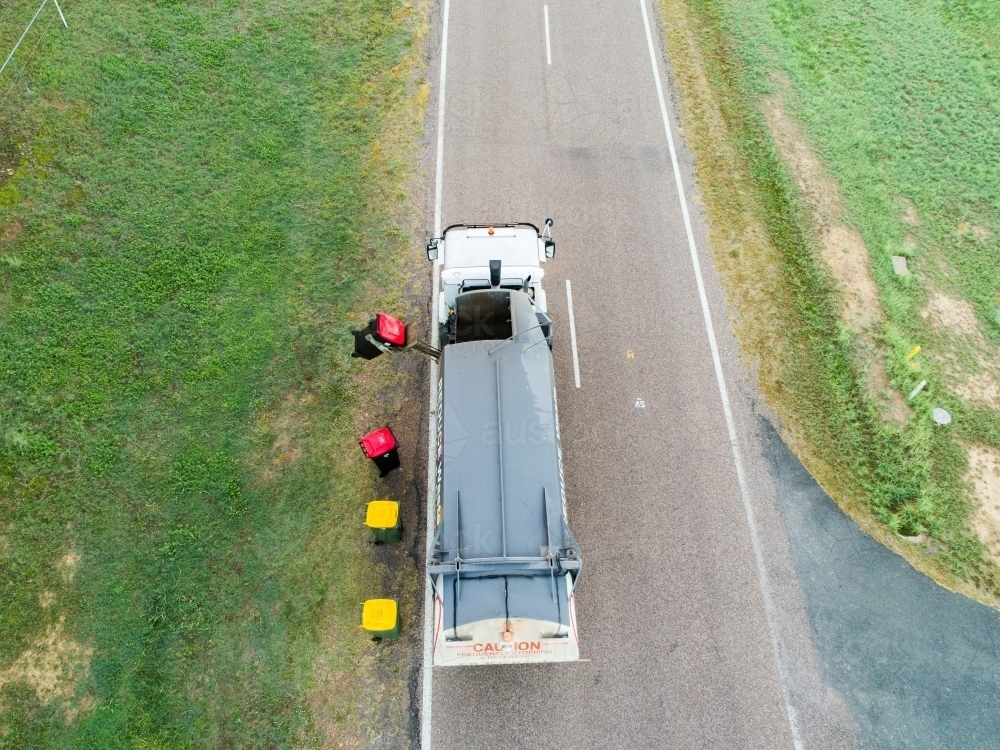 Aerial photo of garbage truck emptying bins in rural location - Australian Stock Image