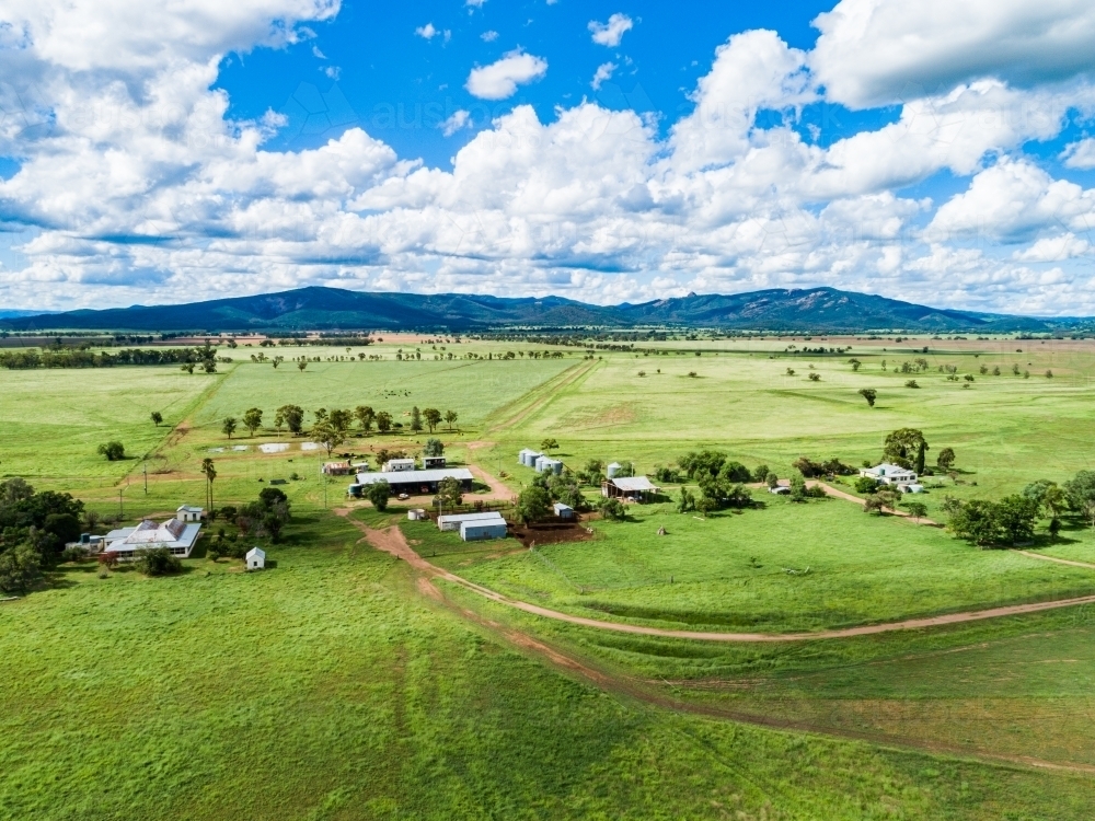 Aerial scene of farm sheds and house among green paddocks - Australian Stock Image
