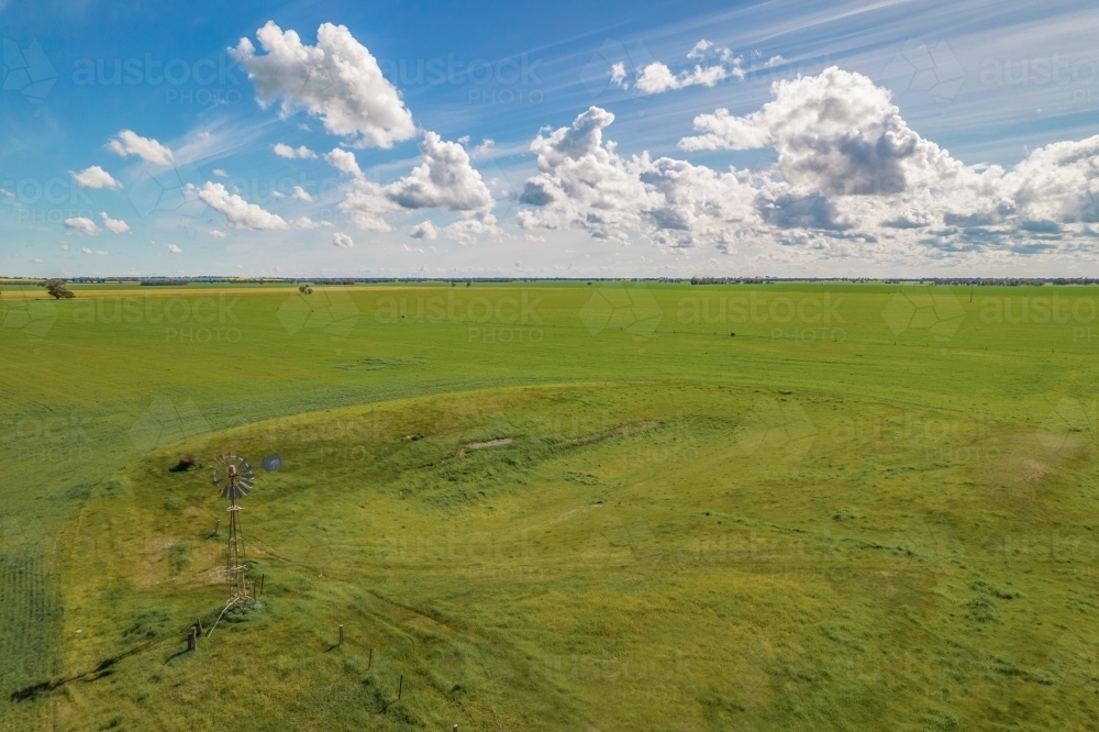 aerial shot of a big open field under cloudy blue skies : Austockphoto aerial shot of a big open field under cloudy blue skies - Australian Stock Image