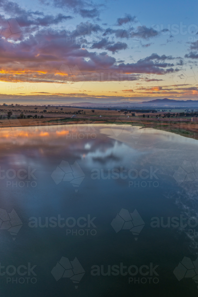 Aerial vertical scene capturing a colourful sunrise over Lake Keepit and the dam wall - Australian Stock Image
