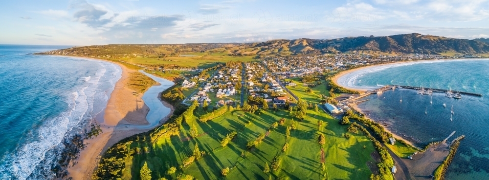 Aerial view a golf course and coastal town with ocean on both sides - Australian Stock Image