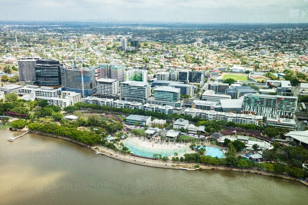 Aerial view across the Brisbane River towards Southbank Parklands and the suburbs beyond - Australian Stock Image