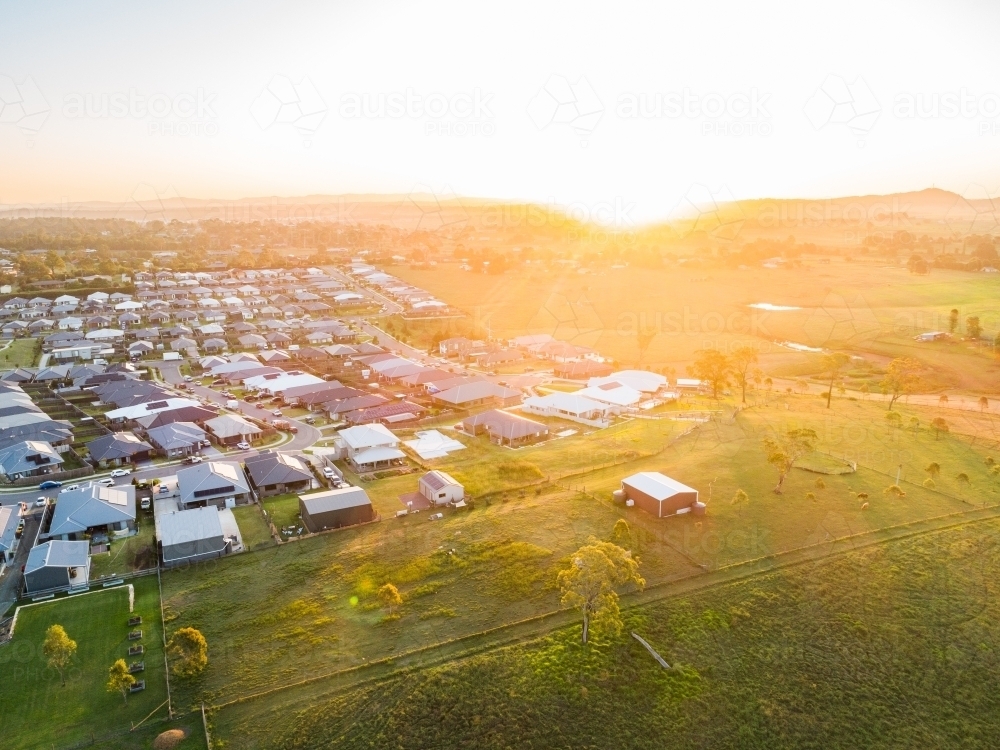 Image of Aerial view at sunset over houses at the edge of town with ...