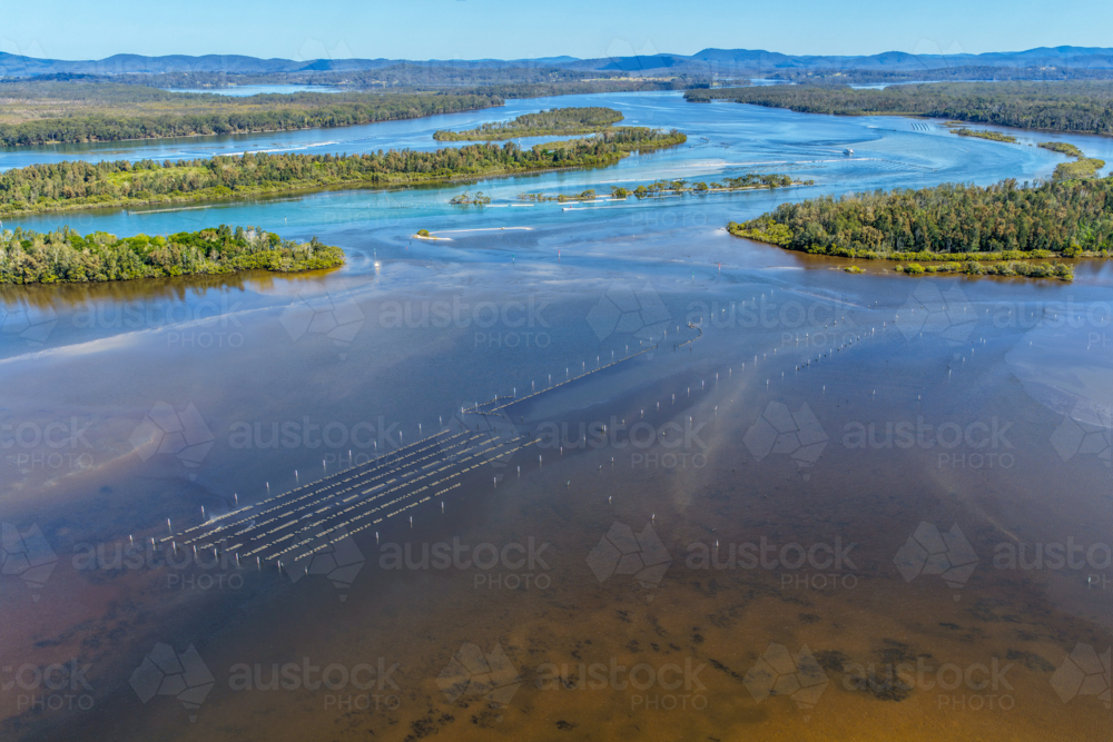 Aerial view capturing the winding river at Tuncurry as it flows around small tree covered islands - Australian Stock Image
