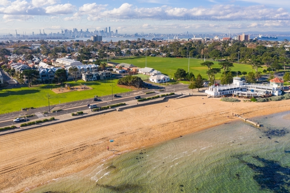 Aerial view of a bay side beach with surrounding parkland and sporting reserves - Australian Stock Image