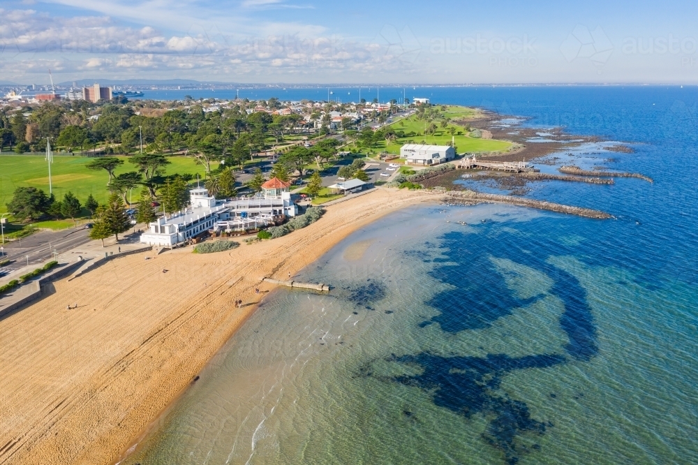 Aerial view of a bay side beach with surrounding parkland and sporting reserves - Australian Stock Image