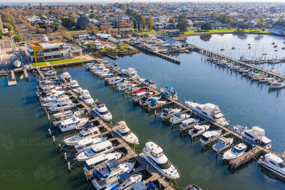 Aerial view of a bay side marina with rows of boats tied to jetties - Australian Stock Image