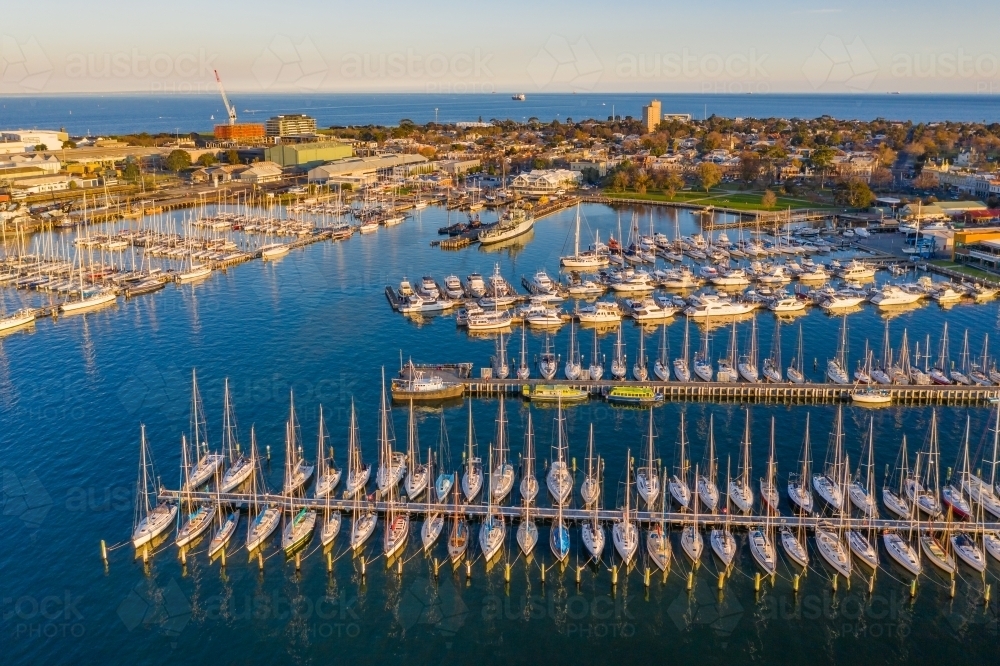 Image of Aerial view of a bay side yacht club with rows of boats lined ...
