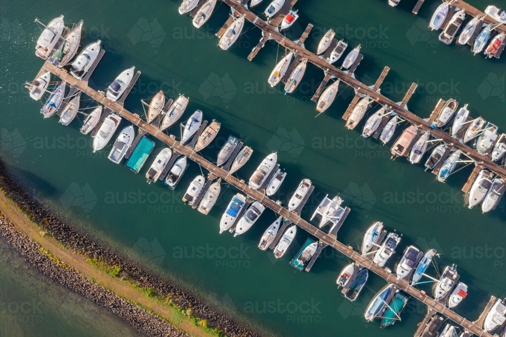 Image of Aerial view of a boats and yachts lined up along jetties at a ...