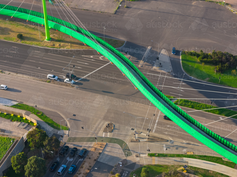 Aerial view of a bright green cycling bridge alongside a highway - Australian Stock Image