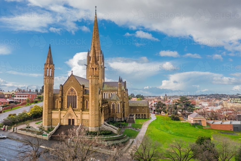 Aerial view of a cathedral on a grassy hillside in a regional city - Australian Stock Image