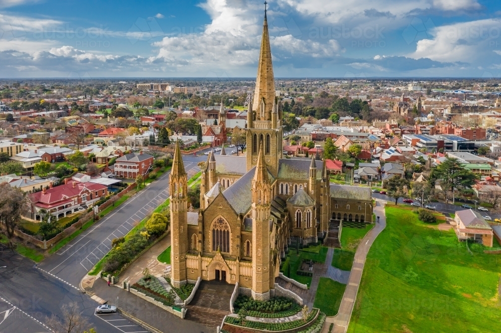 Aerial view of a cathedral on a grassy hillside in a regional city - Australian Stock Image