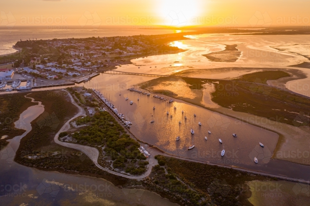 Aerial view of a coastal marina under a golden sunset. - Australian Stock Image
