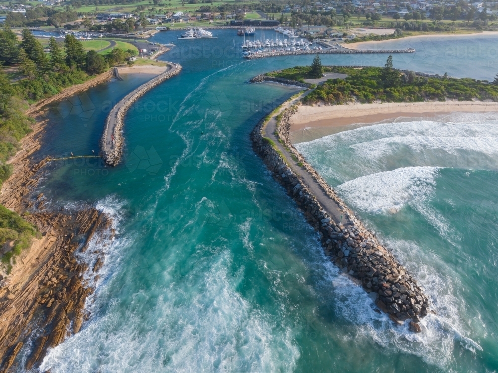 Image of Aerial view of a coastal river flowing out to sea between rock ...