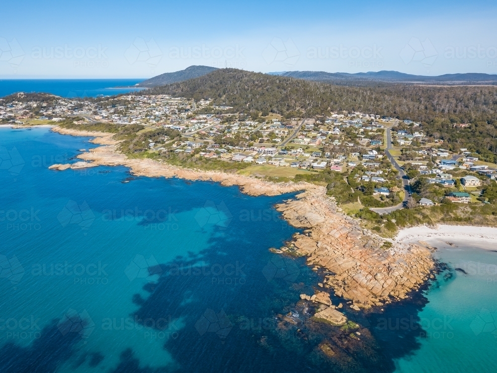 Aerial view of a coastal town behind a rocky shoreline - Australian Stock Image