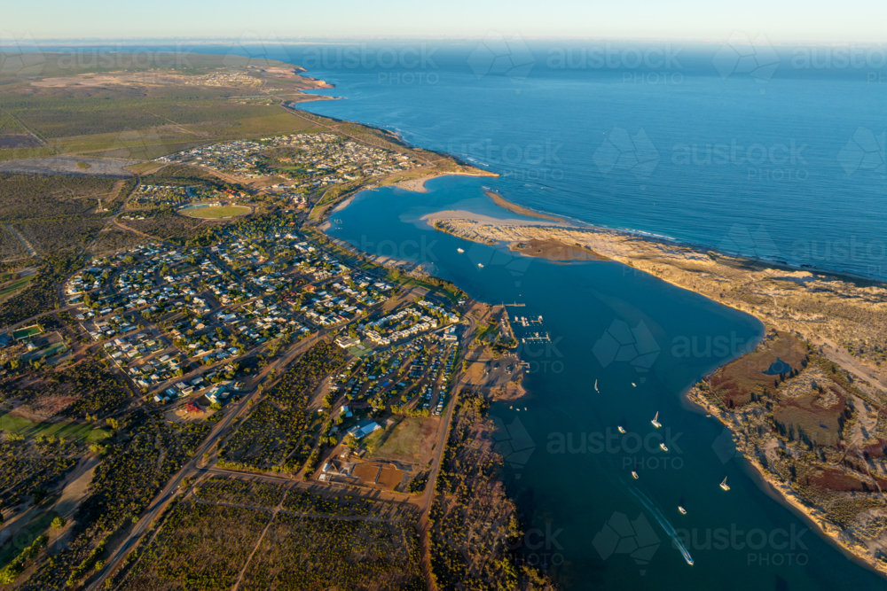 Aerial view of a coastal town, marina and estuary leading into the open ocean. - Australian Stock Image