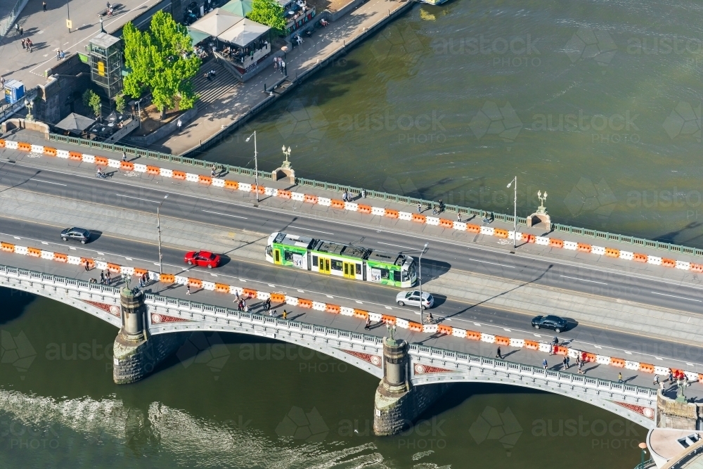 Aerial view of a commuter tram going over an historic arched bridge - Australian Stock Image
