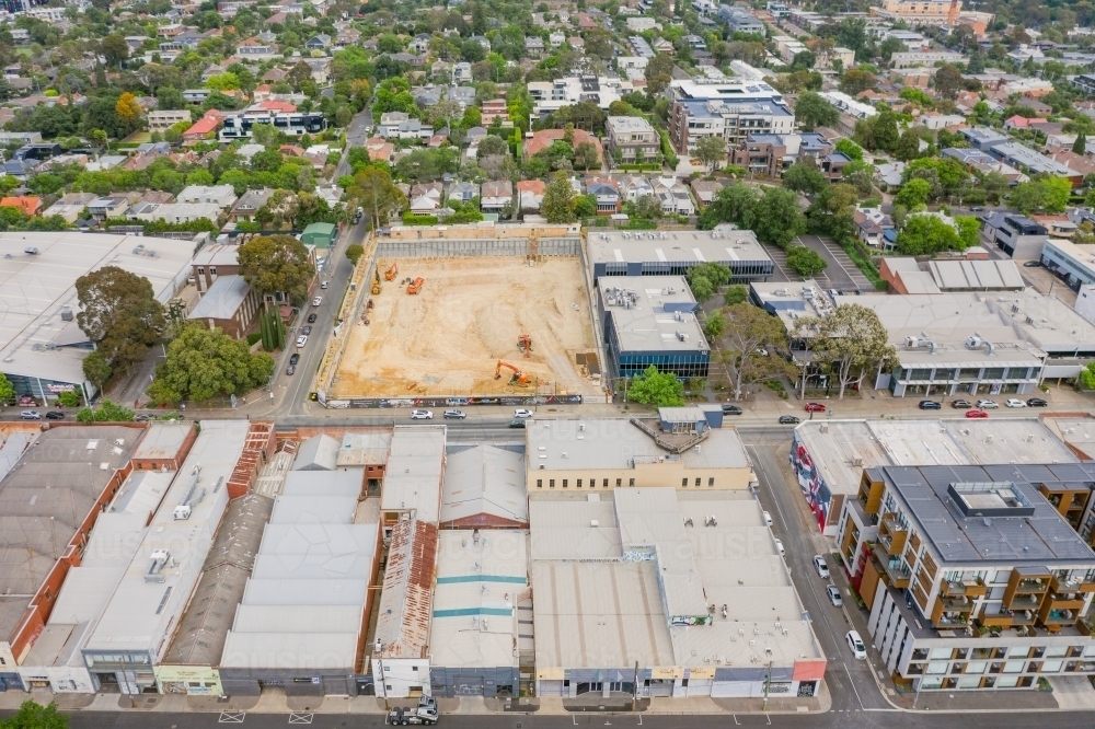 Aerial view of a construction site behind a strip of commercial factories - Australian Stock Image