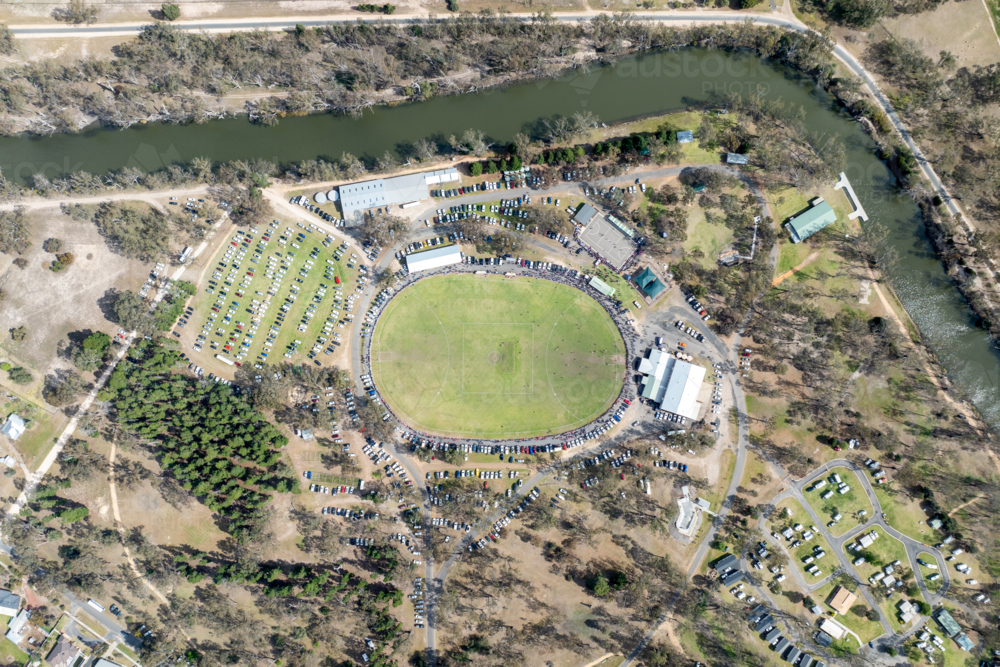 Aerial view of a country football ground beside a winding river during a match. - Australian Stock Image