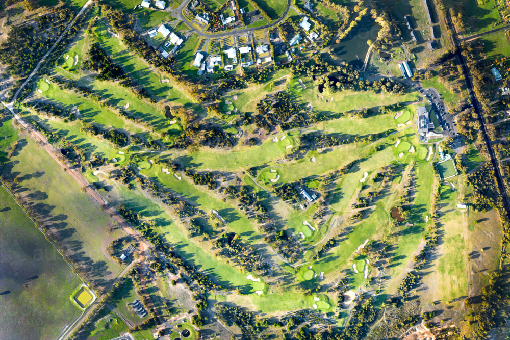 Aerial view of a country golf course bathed in late afternoon light. - Australian Stock Image