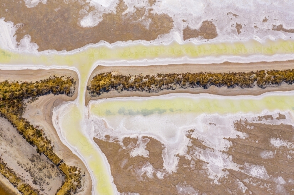 Aerial view of a creek joining two salt evaporation ponds - Australian Stock Image