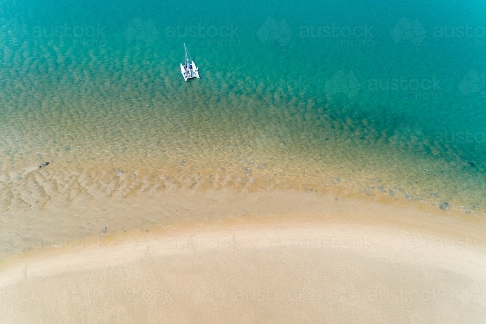 Aerial view of a cruising catamaran anchored near a sandbar, Seventeen Seventy, QLD. - Australian Stock Image