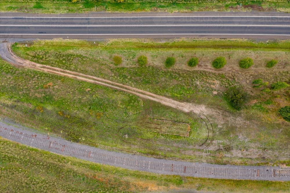 Aerial view of a dirt track off a country road leading to disused railway line - Australian Stock Image