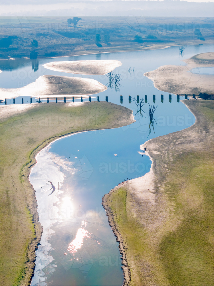 Aerial view of a disused railway bridge through a drying reservoir - Australian Stock Image