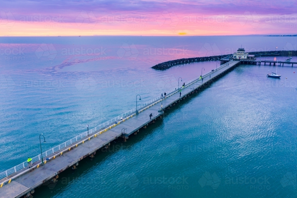 Aerial view of a dramatic purple sunset over a coastal jetty and breakwater - Australian Stock Image