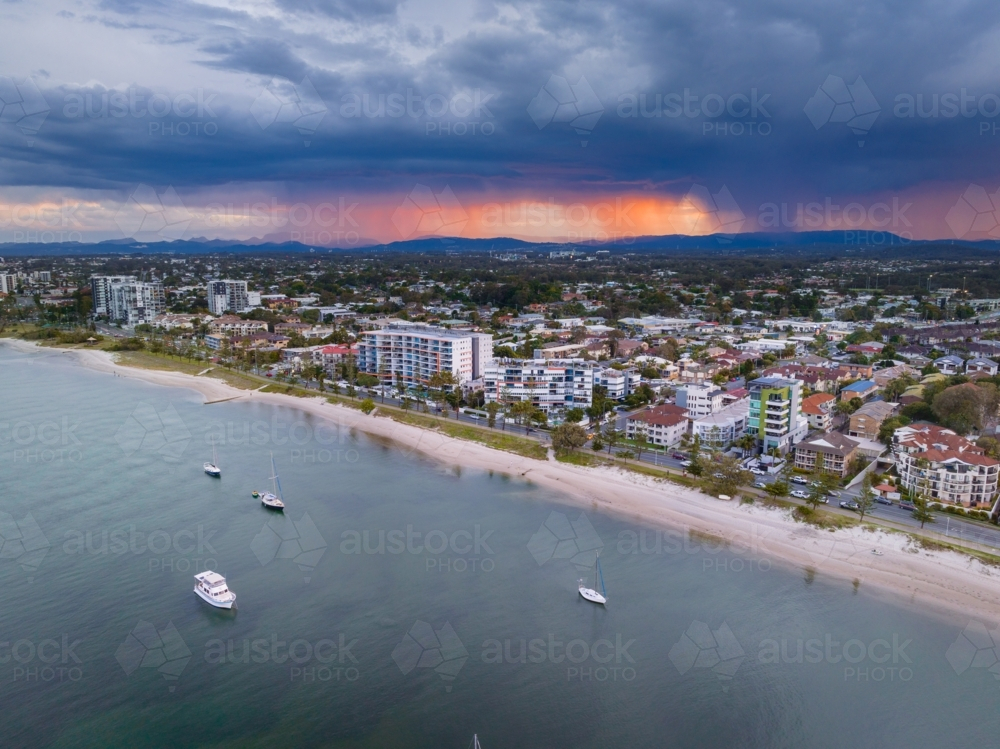 Aerial view of a dramatic thunderstorm advancing over apartment buildings along a coastal esplanade - Australian Stock Image