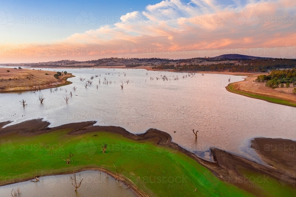 Aerial view of a drying reservoir at sunset. - Australian Stock Image