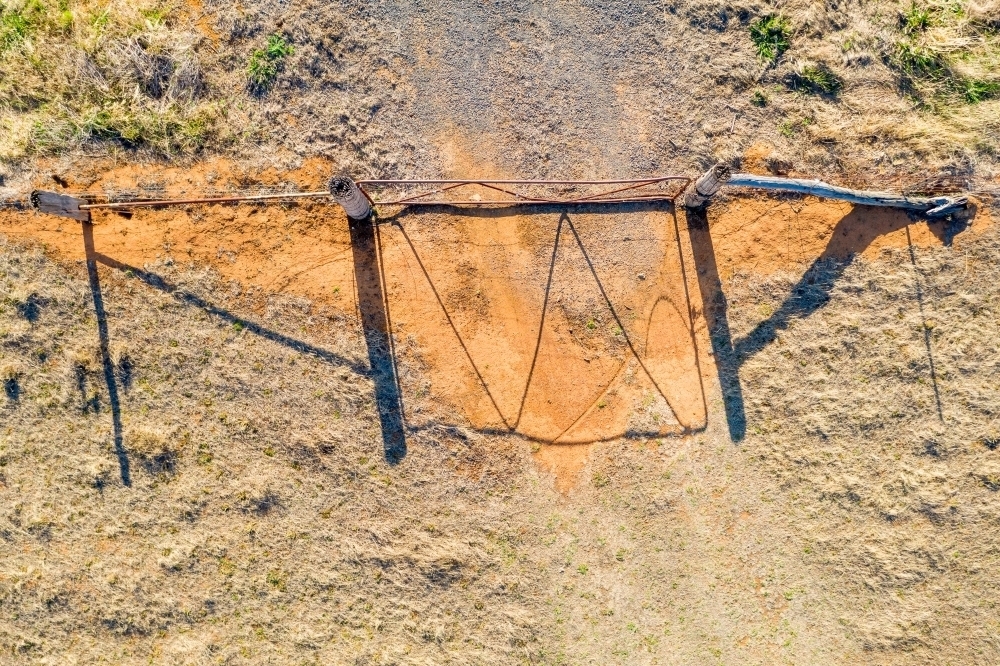 Aerial view of a farm gate and its long shadow - Australian Stock Image