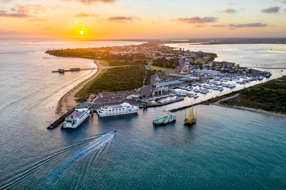 Aerial view of a ferry terminal and boats at a marina at sunset - Australian Stock Image