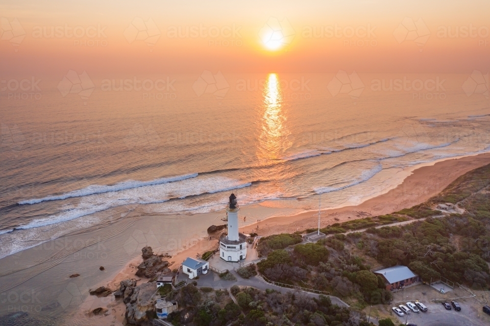 Aerial view of a golden sunset over the Point Lonsdale Lighthouse and coastline - Australian Stock Image
